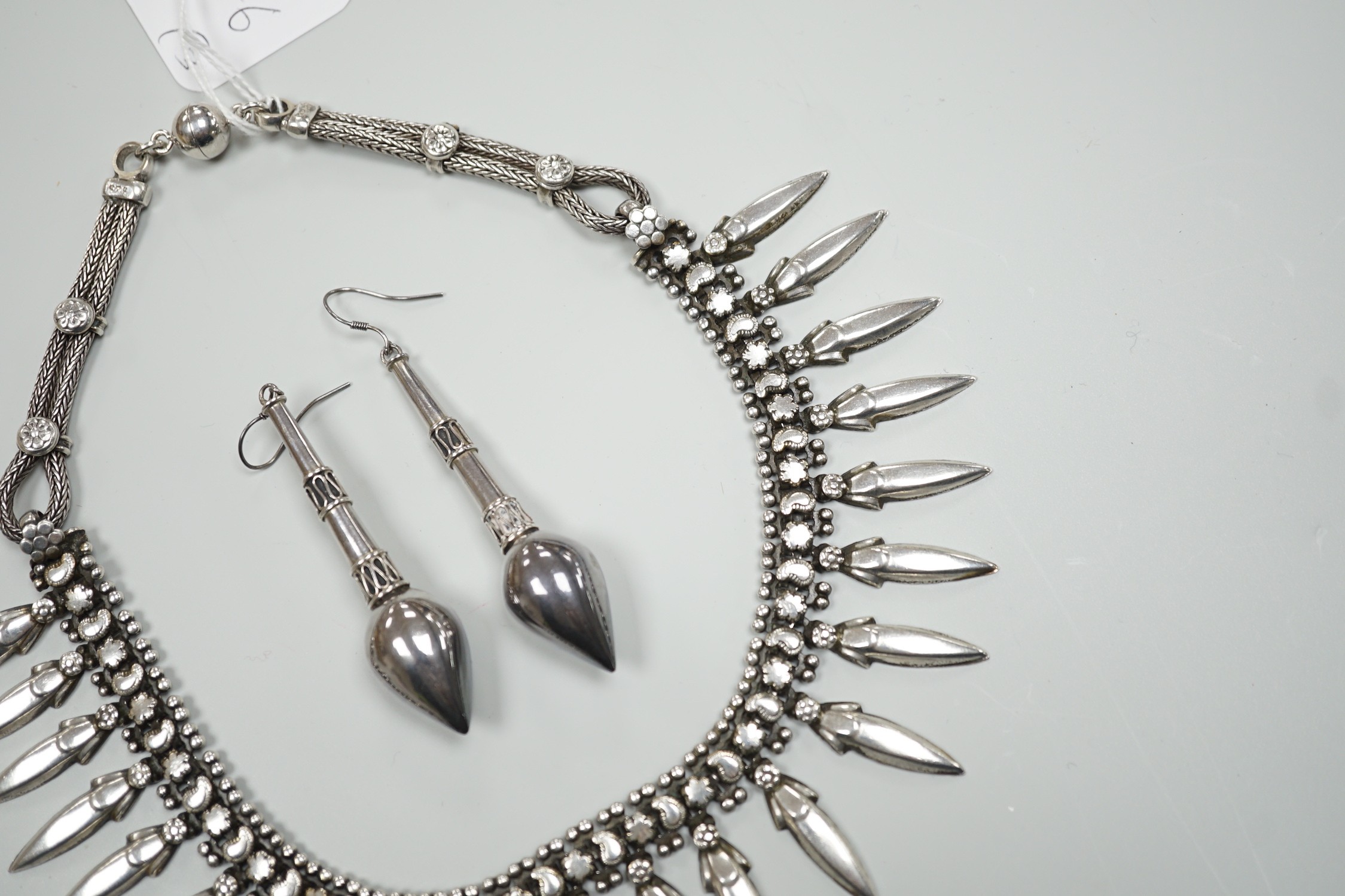 A late 20th century Balinese 925 white metal drop fringe necklace, 43cm, together with a pair of white metal drop earrings, 63mm.